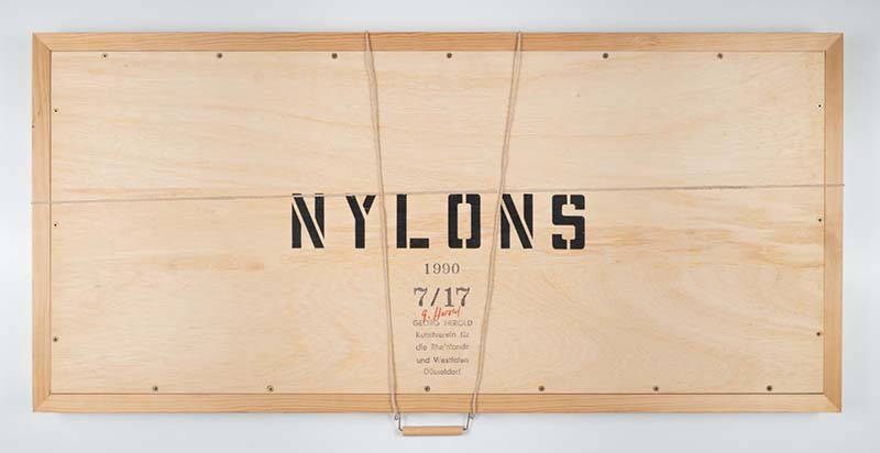 Eine halb geöffnete Holzbox mit der Aufschrift Nylons im Inneren Draht mit Strumpf